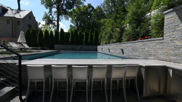 Sunken outdoor kitchen, pool. Hand-chiseled flagstone wall.